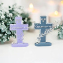 Zwei moderne 3D-gedruckte Kommunionskreuze in Lila und Blau mit Schriftzug „Alles Liebe zur Kommunion“, Tauben- und Blättermotiv auf Standfuß.